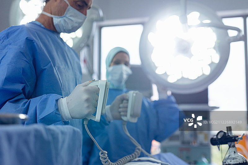 男外科医生在医院手术室拿着除颤器图片素材