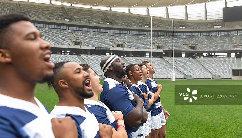 一群不同的男性橄榄球运动员在体育场一起宣誓图片素材
