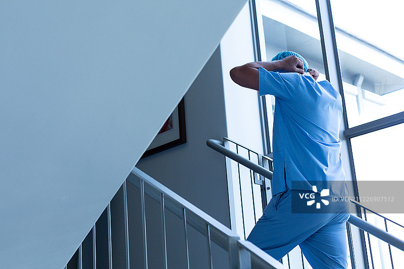 男外科医生戴着外科口罩爬医院楼梯图片素材