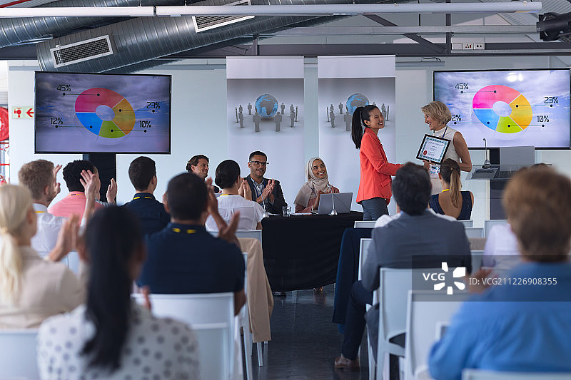 女商人在商务研讨会上领奖图片素材
