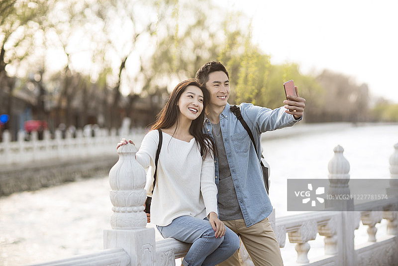 年轻情侣使用手机自拍图片素材