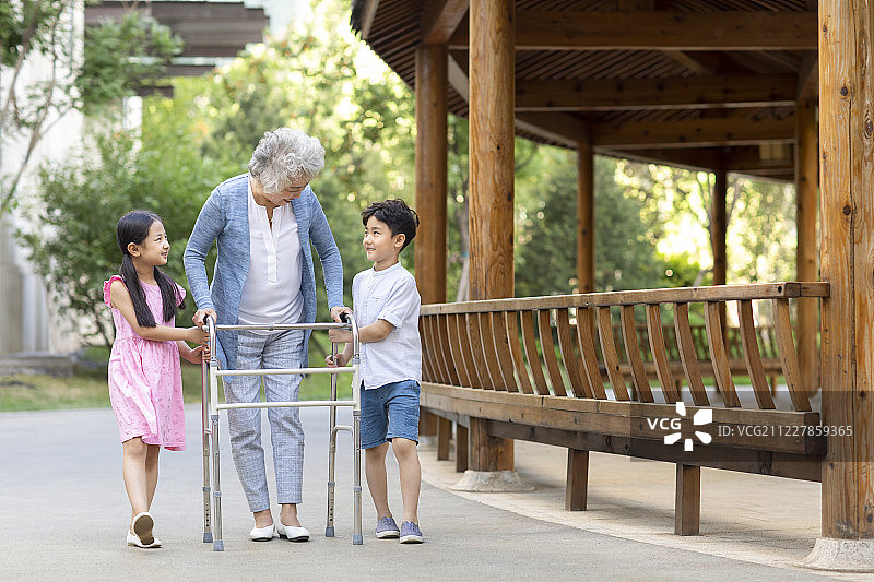 兄妹俩帮助奶奶用助行器走路图片素材