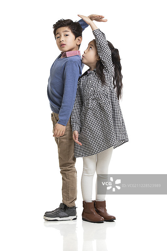 兄妹俩测量身高图片素材