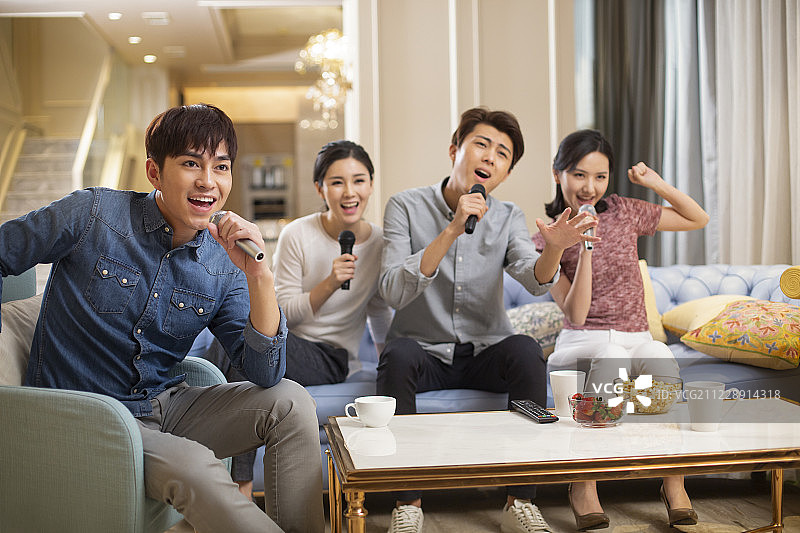 年轻朋友在家唱KTV图片素材