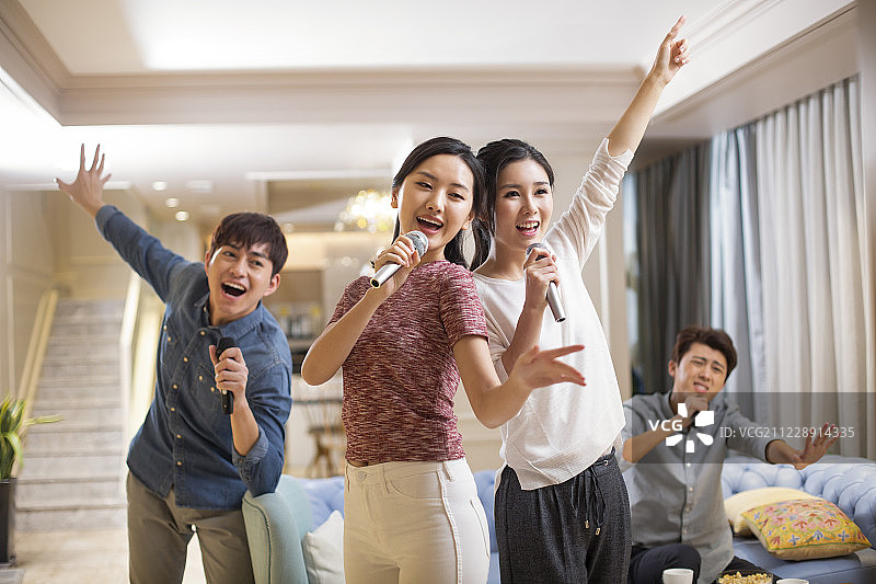 年轻朋友在家唱KTV图片素材