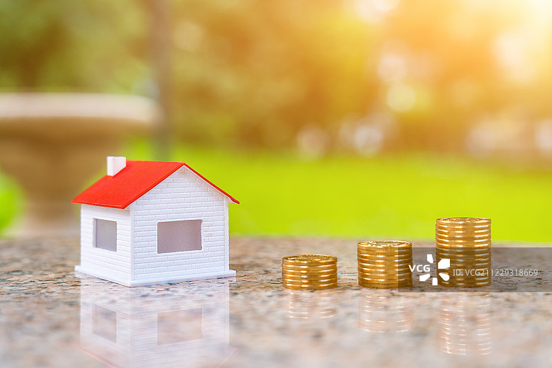 阳光下的小房子和金币图片素材