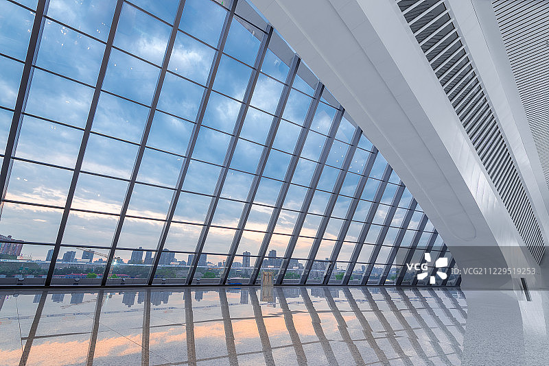 重庆西站的大型落地窗和窗外的带朝霞的城市景观图片素材