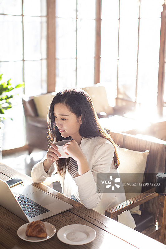年轻商务女士在咖啡店使用电脑图片素材