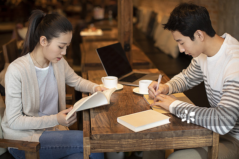 年轻大学生在咖啡店学习图片素材