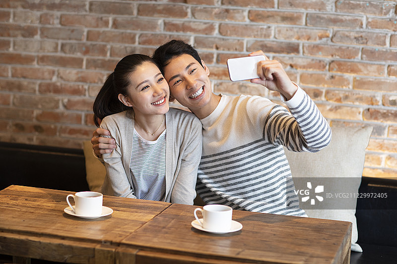 年轻情侣在咖啡店自拍图片素材