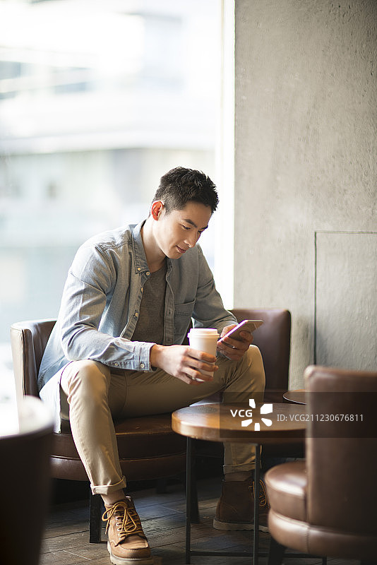 年轻男子在咖啡厅使用手机图片素材