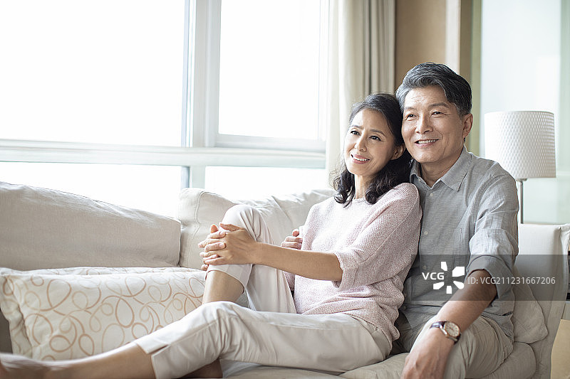 快乐的成熟夫妇坐在沙发上图片素材