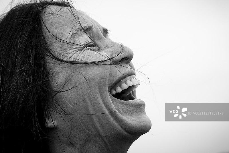 侧脸拍摄的笑容满面的黑发女人头部特写图片素材