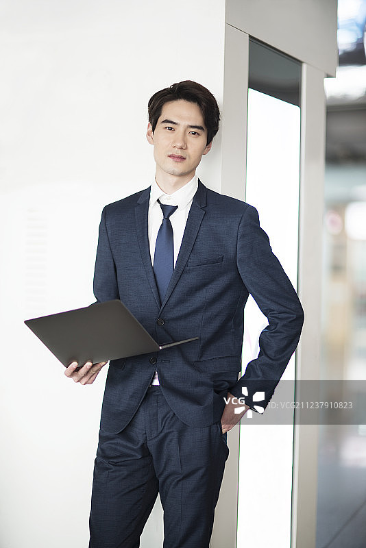 年轻商务男士在机场候机室使用笔记本电脑图片素材