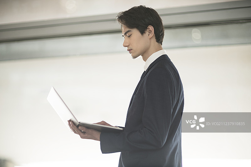 年轻商务男士在机场候机室使用笔记本电脑图片素材
