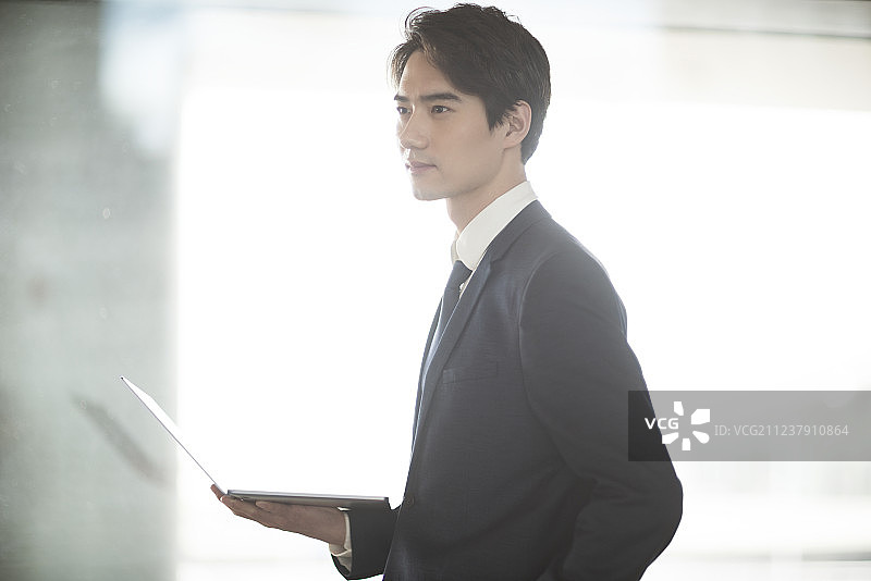 年轻商务男士在机场候机室使用笔记本电脑图片素材