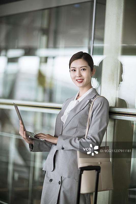 年轻商务女士在机场候机室使用笔记本电脑图片素材