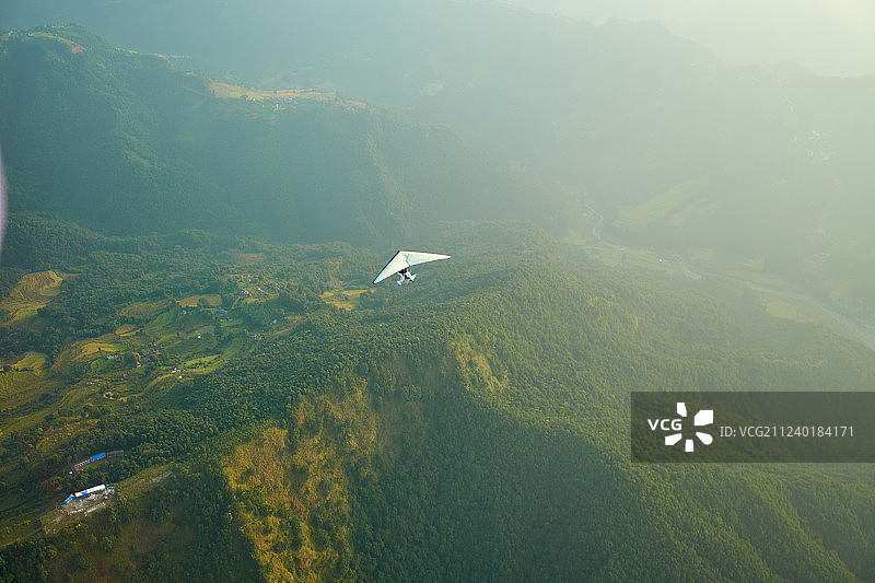 喜马拉雅山脉尼泊尔背景下的超轻型飞机、树木和雪山图片素材