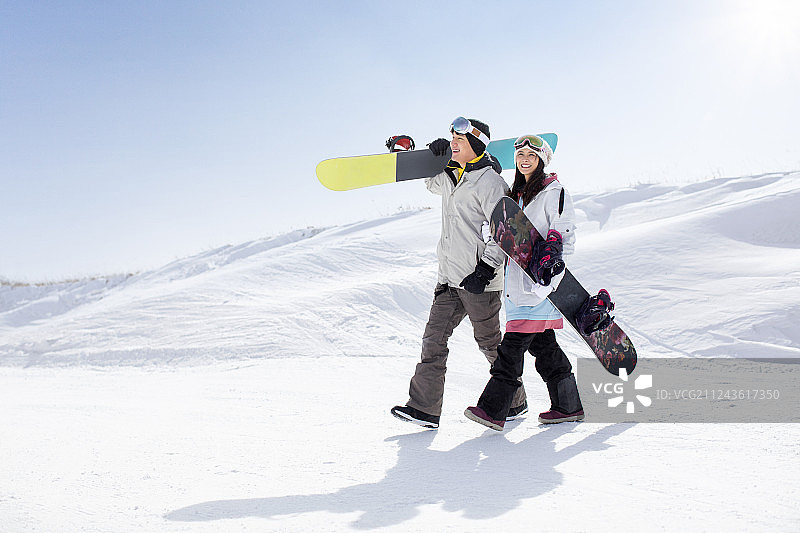 快乐的年轻情侣在滑雪场滑雪图片素材