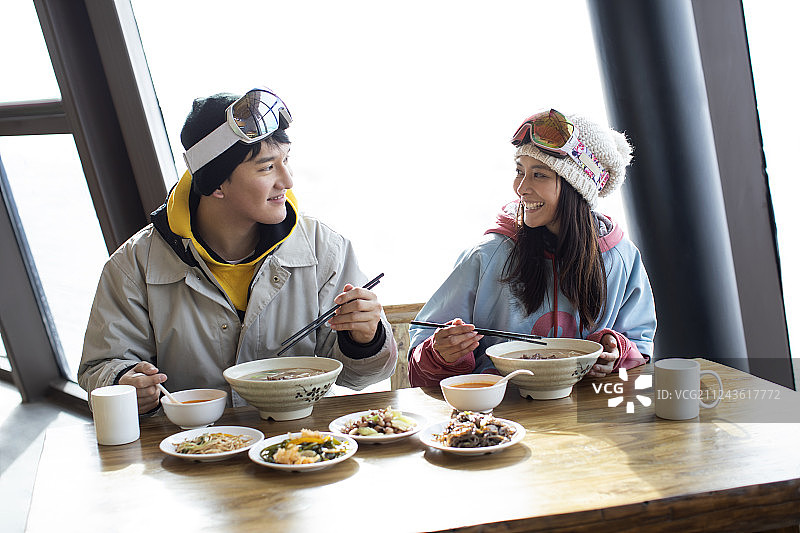 快乐年轻情侣在餐馆吃饭图片素材