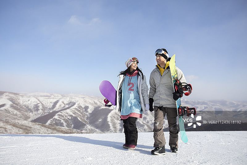 年轻情侣在雪地上行走图片素材