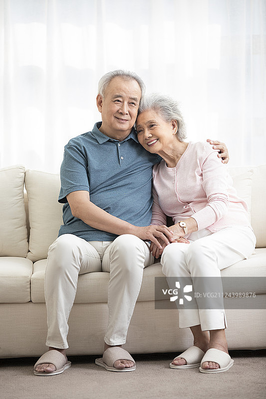 快乐的老年夫妇坐在沙发上图片素材