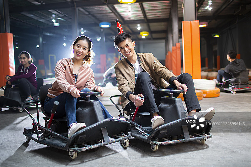 快乐的年轻朋友玩卡丁车图片素材