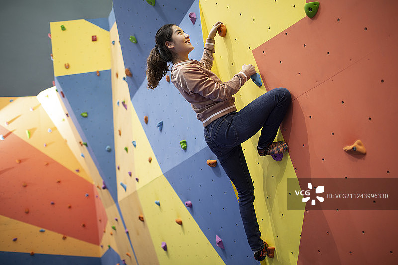 快乐的年轻女孩在健身馆攀岩图片素材
