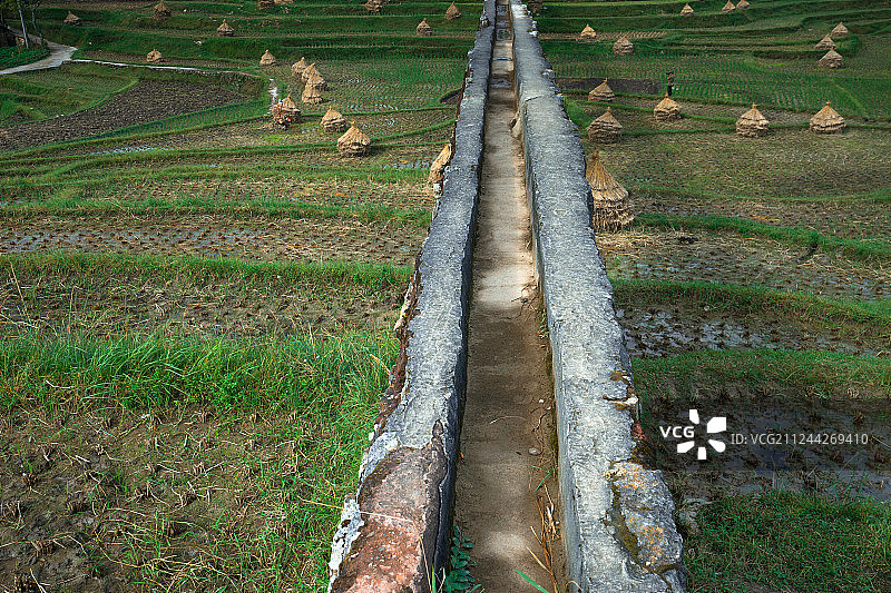 航拍水渠下的梯田与稻草图片素材