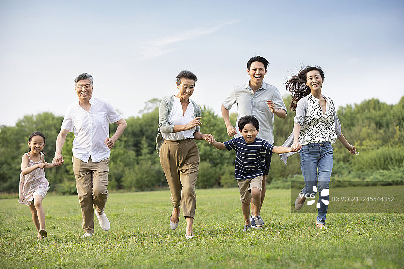 快乐家庭在草地上奔跑图片素材