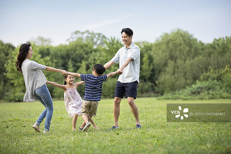 快乐年轻家庭在草地上玩耍图片素材