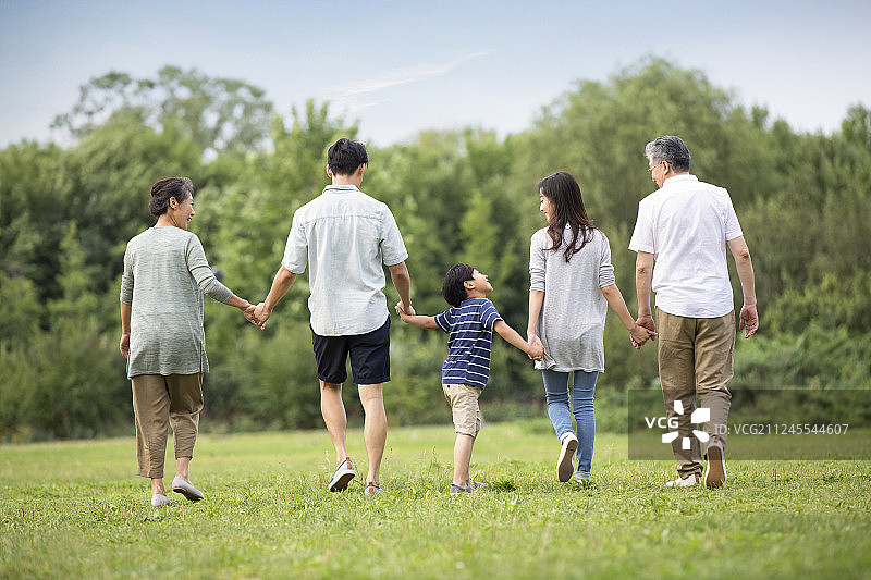 快乐家庭在草地上散步图片素材