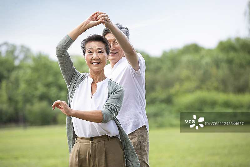 快乐老年夫妇在草地上跳舞图片素材