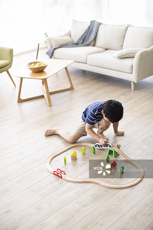 小男孩在客厅玩火车玩具图片素材