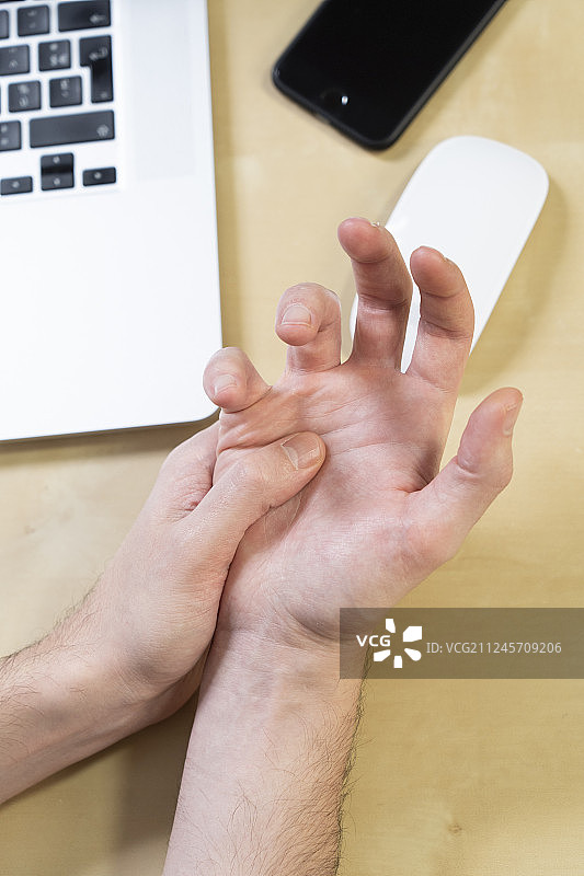 男子因长时间使用鼠标而手部疼痛特写图片素材