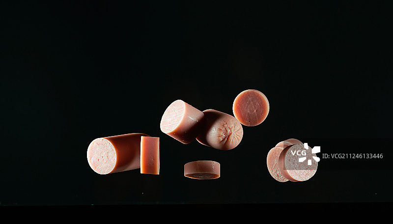 跳跃的火腿肠高速棚拍黑底创意摄影广告素材图片素材