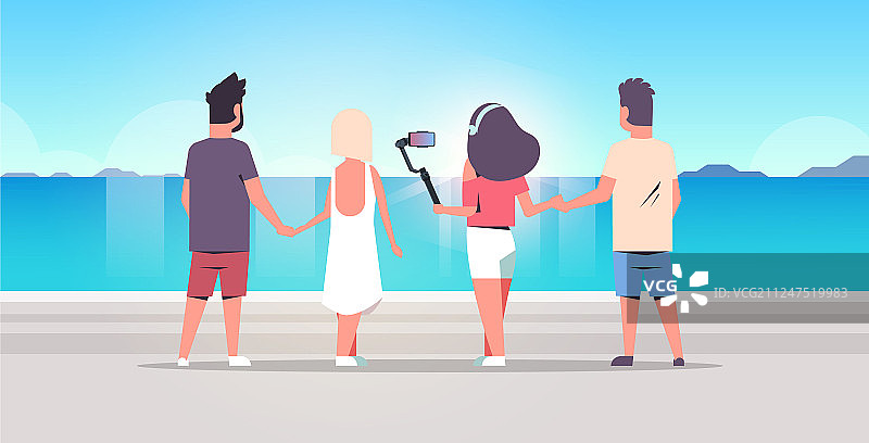 在海滩上用自拍杆自拍的人群图片素材