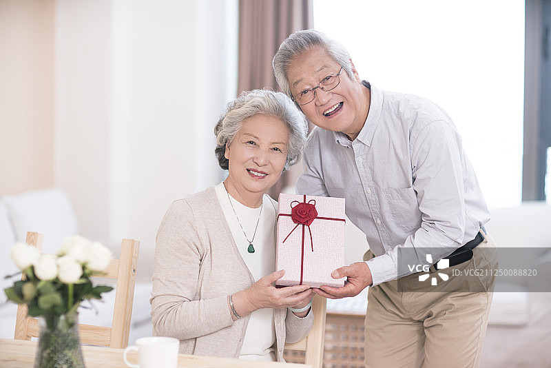 老年男子送礼物给妻子图片素材