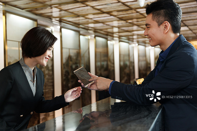 商务男士办理酒店入住登记图片素材