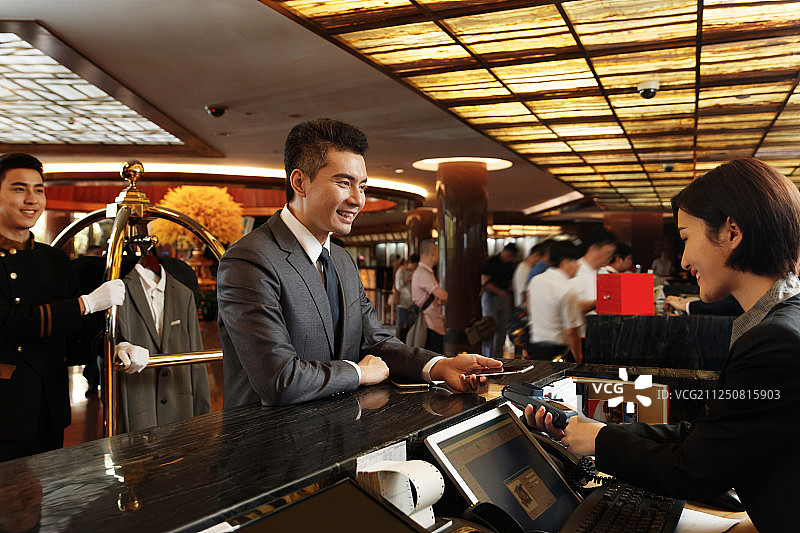 商务男士办理酒店入住登记图片素材