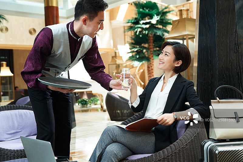 酒店服务员给顾客端水图片素材