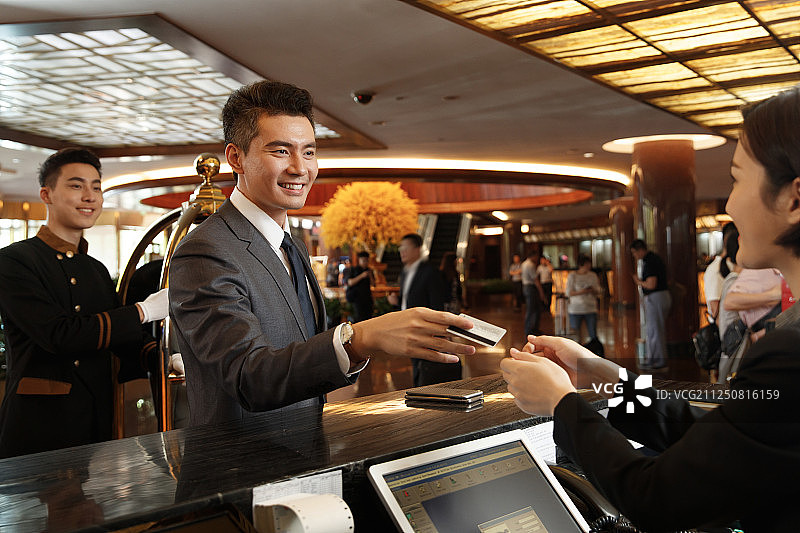 商务男士办理酒店入住登记图片素材