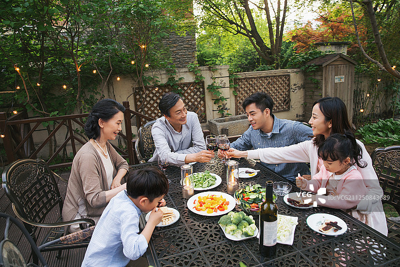 快乐大家庭在庭院里用餐图片素材