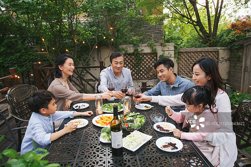 快乐大家庭在庭院里用餐图片素材