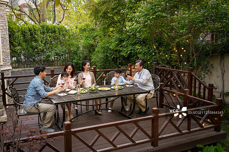 快乐大家庭在庭院里用餐图片素材
