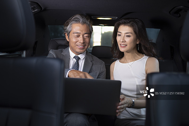 成功商务人士在车里使用笔记本电脑图片素材