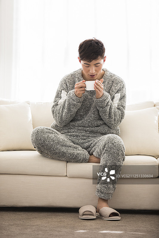 年轻男士在客厅喝咖啡图片素材