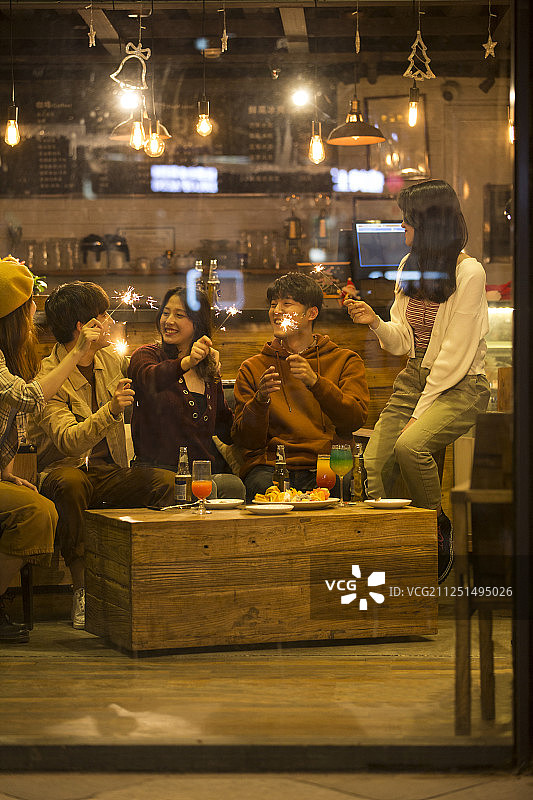 五个青年男女一起在酒吧聚会嬉戏放烟花欢度圣诞节图片素材