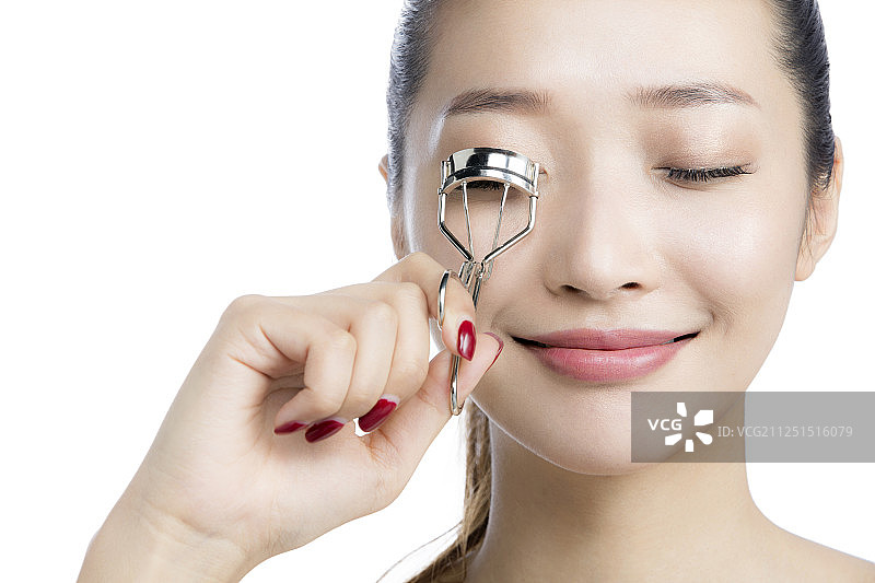 拿着睫毛夹的年轻女士图片素材