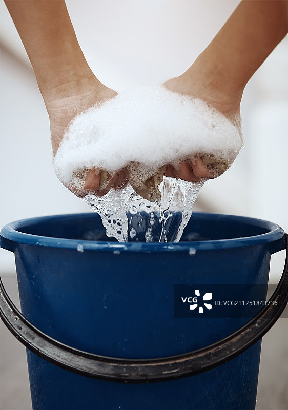 人们拧干沾有肥皂泡的清洁抹布图片素材